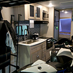 Adrenline 21LT Interior Showing Kitchen, Sofa In Stow Position and a Motorcycle May Show Optional Features. Features and Options Subject to Change Without Notice.