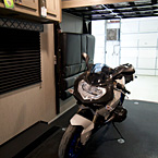 Adrenline 21LT Interior Showing Motorcycle in Cargo Area with Sofa in Stowed Position May Show Optional Features. Features and Options Subject to Change Without Notice.