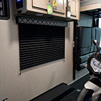 Adrenline 21LT Interior Showing Travel Trailer Wheel Well in Cargo Area and Cabinets Above Window May Show Optional Features. Features and Options Subject to Change Without Notice.