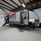 Door Side View from Front- Awning Extended with LED Lights (Shown in Red), Two Exterior Doors Opened Up with Optional Solid Steps and Flip-down Steps, Pass-through Storage Opened-Up May Show Optional Features. Features and Options Subject to Change Without Notice.