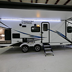 Door Side Awning Extended with LED Light Strip, Camp Kitchen Door Open, Griddle and Side Table Mounted and Pass Through Storage Open
 May Show Optional Features. Features and Options Subject to Change Without Notice.