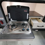 Camp Kitchen with Two Burner Cook Top Open Next to Drawer Shown Open
 May Show Optional Features. Features and Options Subject to Change Without Notice.
