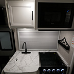 Microwave Above Stovetop and Cabinet Above Sink with Oven Knob Lights Shown On
 May Show Optional Features. Features and Options Subject to Change Without Notice.