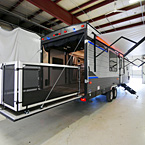 Rear and Door Side with Optional Ramp Patio Kit Shown Extended. Awning Extended with Red LED Lights Shown On.
 May Show Optional Features. Features and Options Subject to Change Without Notice.
