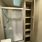 Glass Shower Doors Shown Open Next to Linen Closet Shown Open with Six Shelves. 
 May Show Optional Features. Features and Options Subject to Change Without Notice.