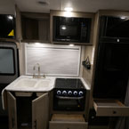 Three Cabinet Doors and Two Drawers Shown Open in the Kitchen Galley. 
 May Show Optional Features. Features and Options Subject to Change Without Notice.