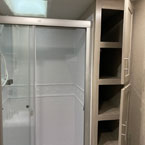 Double Door Linen Closet in Bathroom Shown Open, Next to Glass Shower Door Shown Open. 
 May Show Optional Features. Features and Options Subject to Change Without Notice.