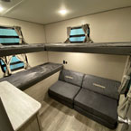 Bunk Room with Three Bunk- Two on the Door Side, One at the Rear with Two Coachmen Cube Charis Below. 
 May Show Optional Features. Features and Options Subject to Change Without Notice.