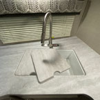 White Double Bowl Sink with Stainless Steel Pull-Down Faucet. Sink Cover Shown to the Side.
 May Show Optional Features. Features and Options Subject to Change Without Notice.