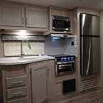 Kitchen Galley- Two Cabinet Doors and Microwave Overhead. Stainless Steel Faucet Over Double Bowl Sink Next to Oven/Stove Top, Three Drawers and one Door Below. Stainless Refrigerator Next to Oven/Stove Top.
 May Show Optional Features. Features and Options Subject to Change Without Notice.