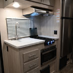 Kitchen Galley with Cabinets Overhead of Single Bowl Sink, Two Burner Cook Top. Three Drawers Below Sink, Microwave Below Cook Top.
 May Show Optional Features. Features and Options Subject to Change Without Notice.