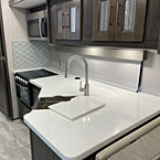 view of kitchen, stainless Steel farmhouse sink, Solid Surface Sink Covers and backsplash and cabinets
 May Show Optional Features. Features and Options Subject to Change Without Notice.