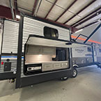 Rear quarter view with slide-out and camper kitchen panel open May Show Optional Features. Features and Options Subject to Change Without Notice.