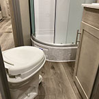 View of inside bathroom with marine toilet with foot flush, shower and sink
 May Show Optional Features. Features and Options Subject to Change Without Notice.