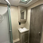 Bathroom shower with sliding glass door and sink with mirrored medicine cabinet and door to bedroom shown closed
 May Show Optional Features. Features and Options Subject to Change Without Notice.