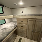 View into bunkroom with three bunk mats and wardrobe storage cabinets with drawers May Show Optional Features. Features and Options Subject to Change Without Notice.